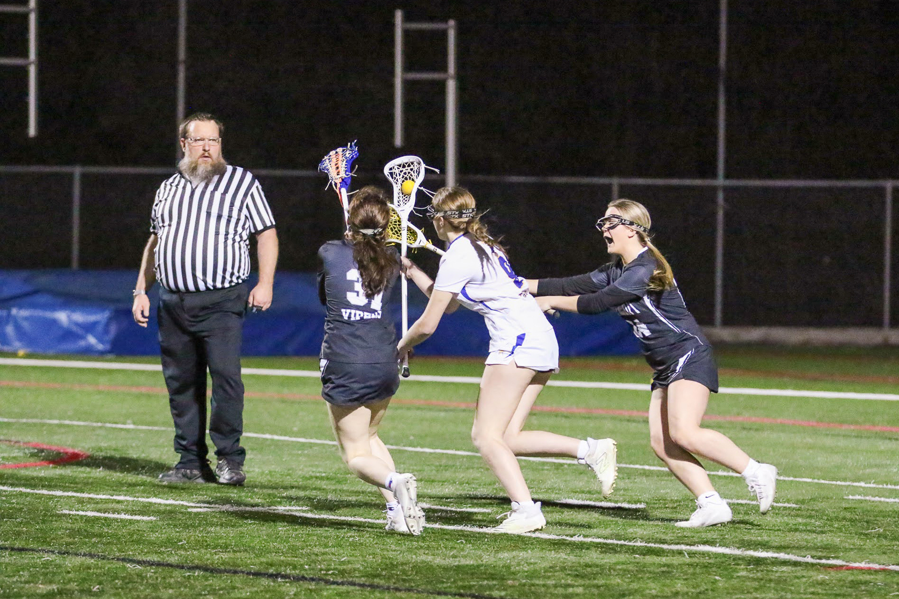 photo of a lacrosse official running backwards while watching a player with the ball on a fast break