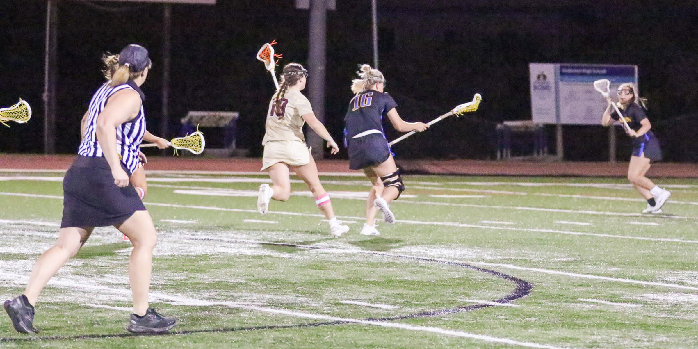 photo of lacrosse official running while observing the interaction between lacrosse players